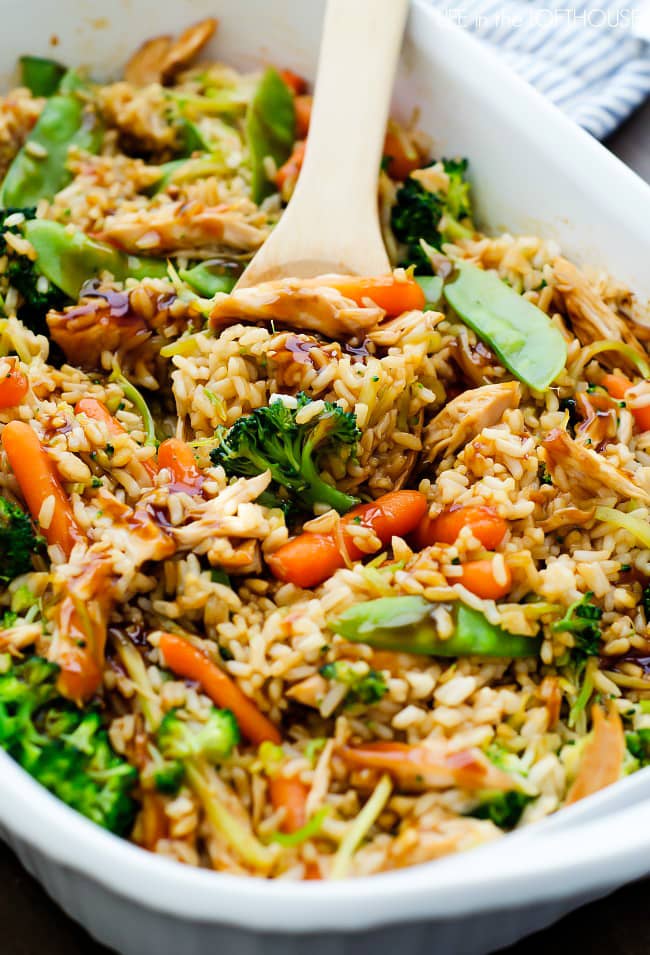 Healthy Teriyaki Chicken Casserole in a white casserole dish with a wooden spoon