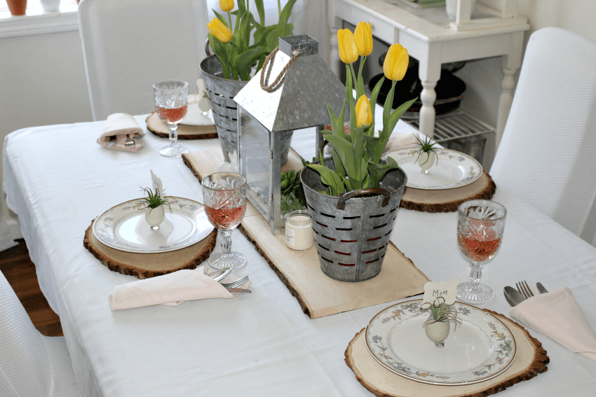 Easter place card, egg shell with air plant and name card tucked into egg. Yellow tullip and galvanized bucket centerpiece.