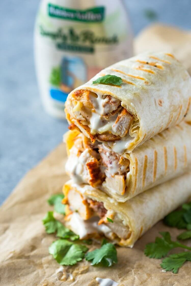 School Lunch Ideas for Kids - stack of chicken ranch wraps on brown paper background with cilantro leaves