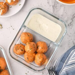 Buffalo turkey meatballs in a meal prep container.