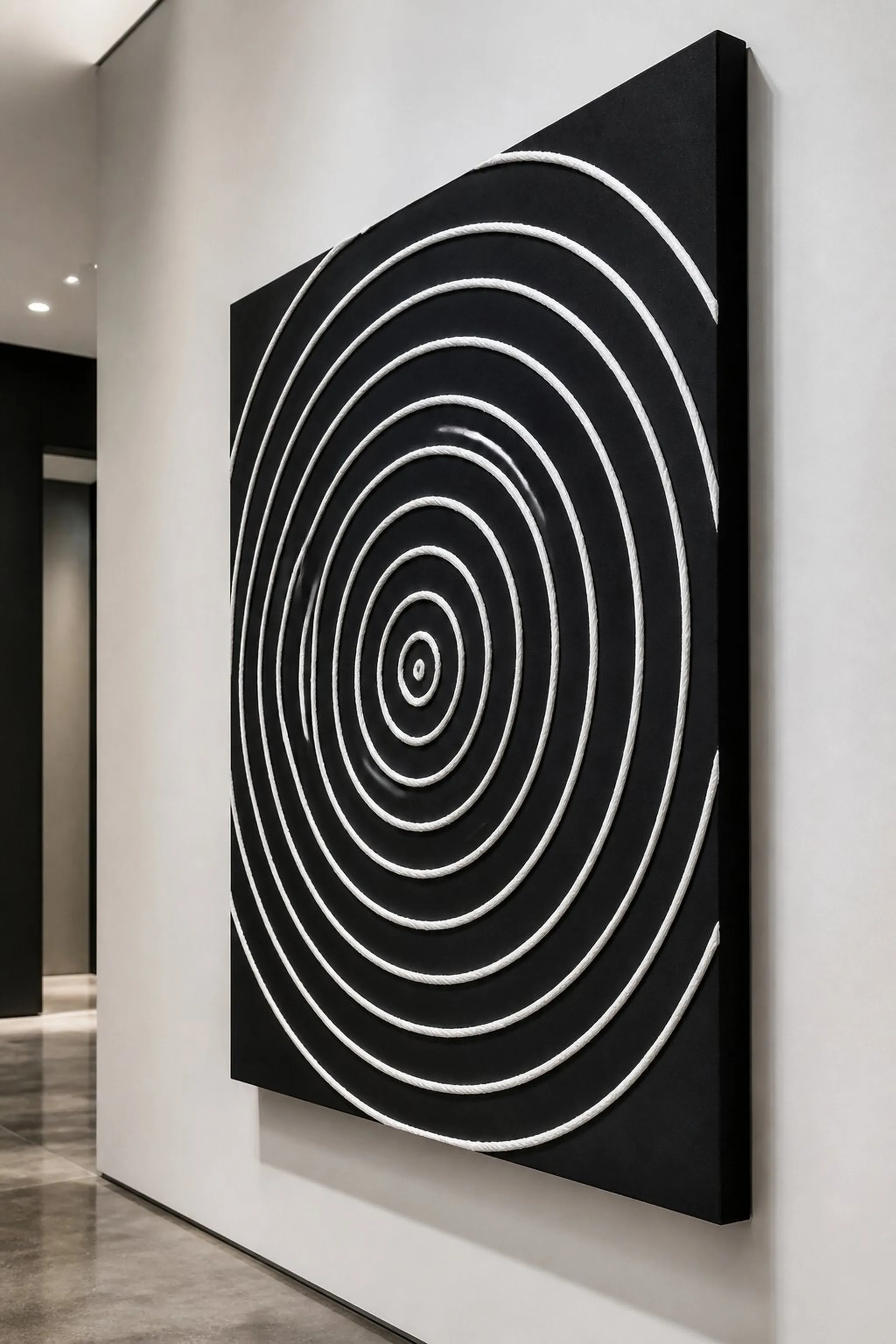 Minimalist white yarn circle art on black canvas