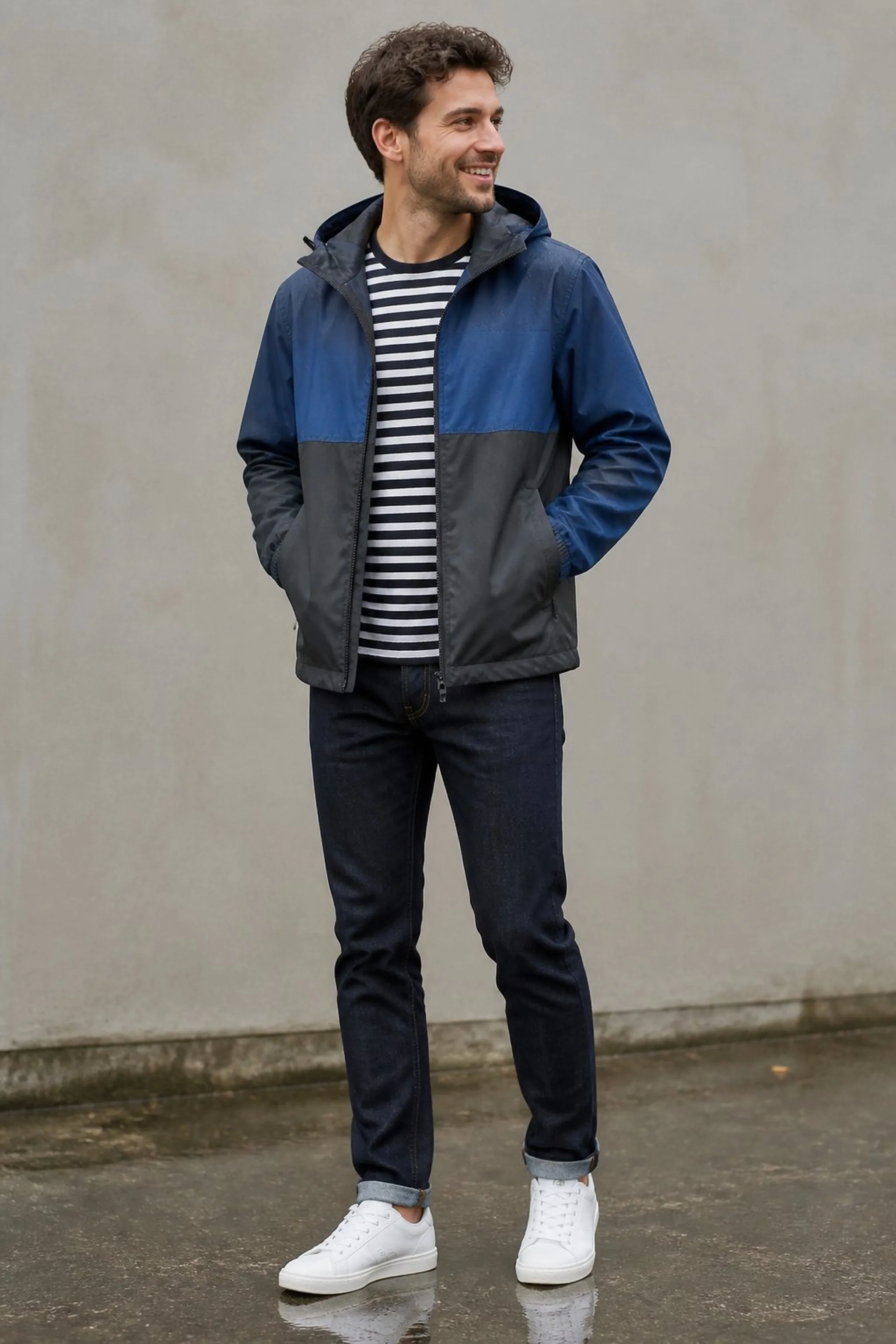Color-blocked rain jacket layered over striped tee